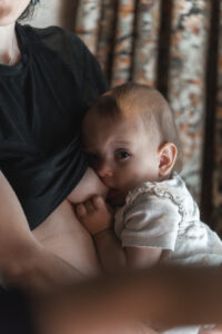 Bébé qui tète le sein de sa maman en regardant l'objectif au restaurant ganache de Bordeaux