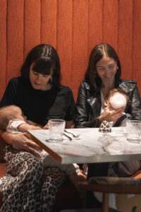 Deux mamans assisent sur une banquette et qui nourrissent leur bébé, l'une au sein et l'autre au biberon dans le restaurant ganache à bordeaux