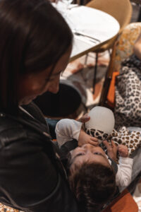 Photo en contreplongée d'une maman qui donne le biberon à son bébé dans le restaurant ganache de Bordeaux
