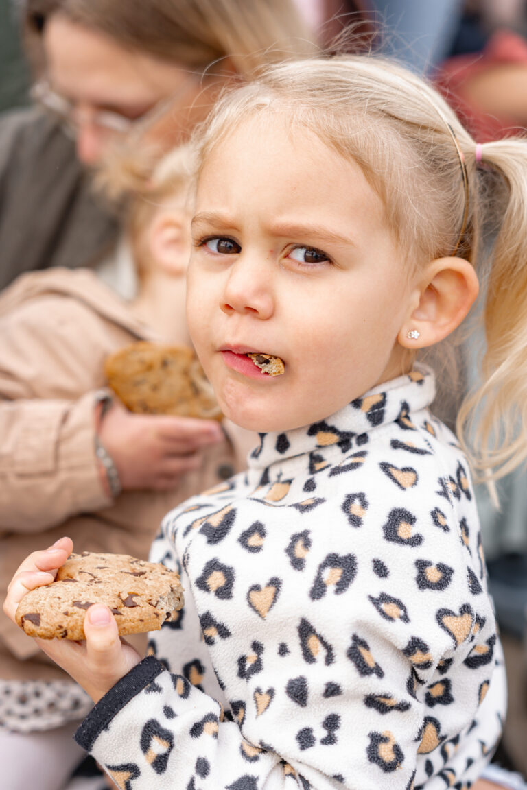 Petite fille qui mange un cookie en regardant l'objectif pendant #jaifaimjemange2024 à Bordeaux