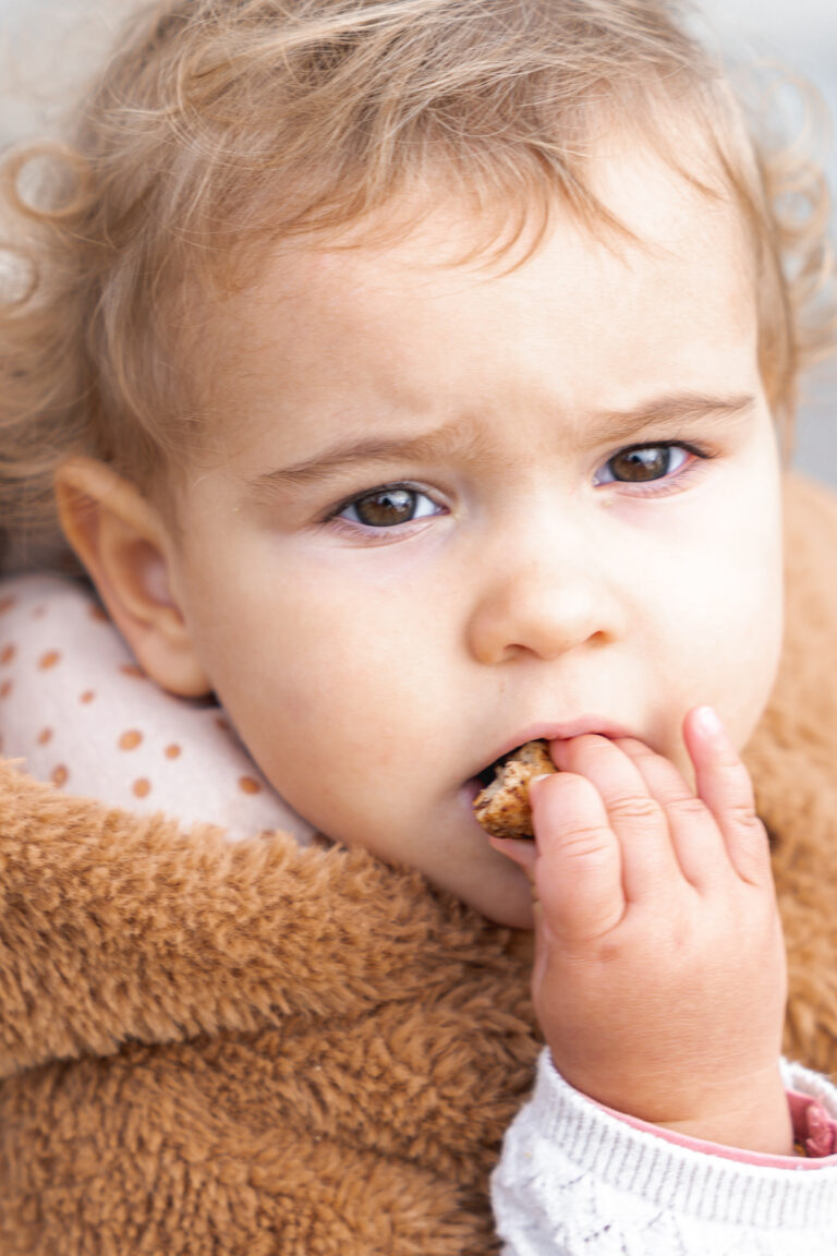 Petite fille qui mange un cookie en regardant l'objectif lors de #jaifaimjemange 2024 à Bordeaux