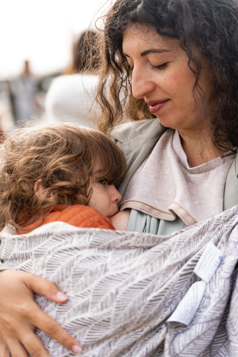 Maman qui allaite son petit garçon en le tenant dans une écharpe de portage lors de #jaifaimjemange 2024 à Bordeaux