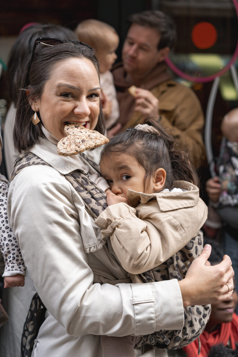 Maman qui tient un cookie dans sa bouche en allaitant sa fille pendant #jaifaimjemange 2024 à Bordeaux