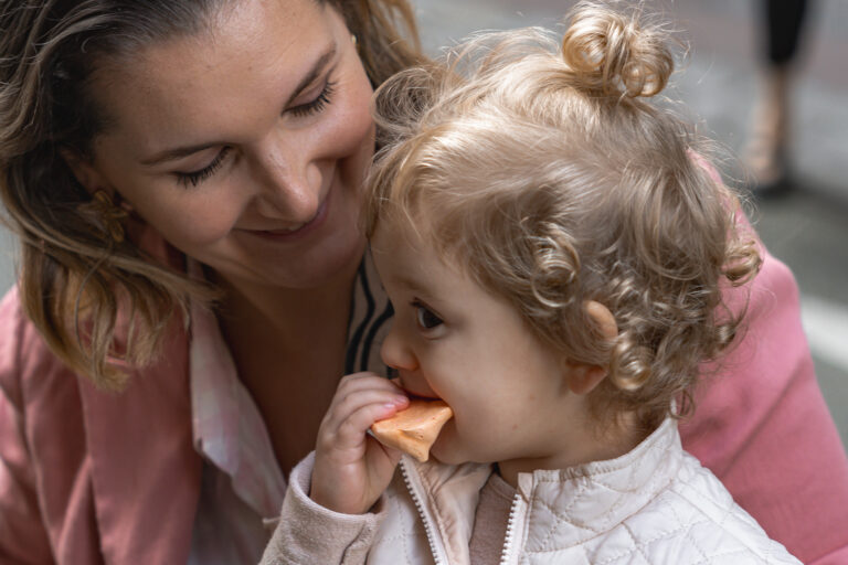 Maman qui sourit à sa fille qui mange un biscuit lors de #jaifaimjemange 2024 à Bordeaux