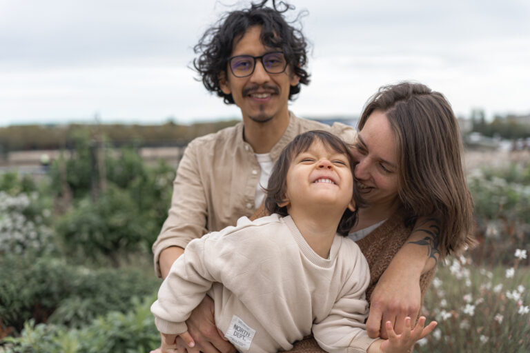Parents qui rient avec leur fils qu'ils chatouillent lors des portraits de famille de #jaifaimjemange 2024 à Bordeaux