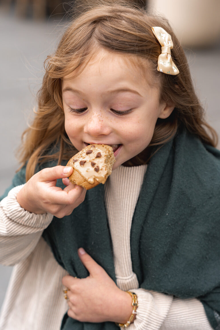 Petite fille qui mange un cookie devant la mairie de bordeaux par photographe bordeaux lors de #jaifaimjemange 2025