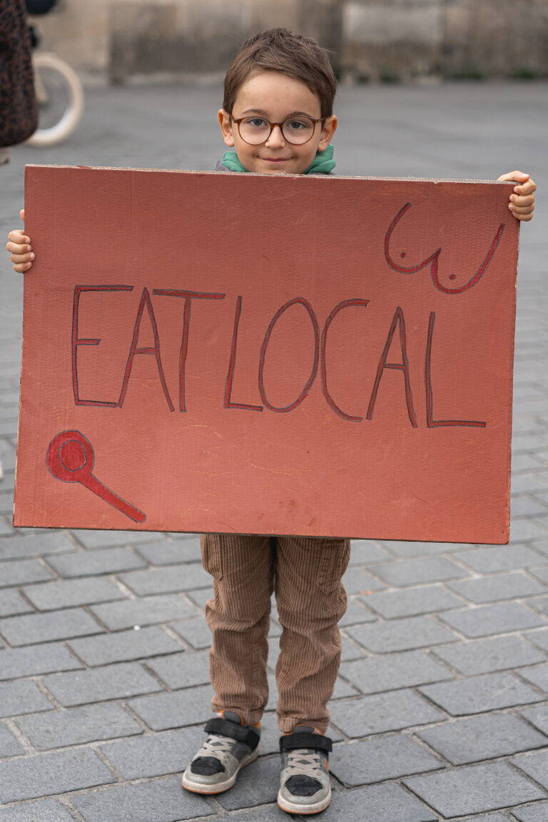 Petit garçon qui tient une pancarte lors de #jaifaimjemange 2025 devant la mairie par photographe bordeaux