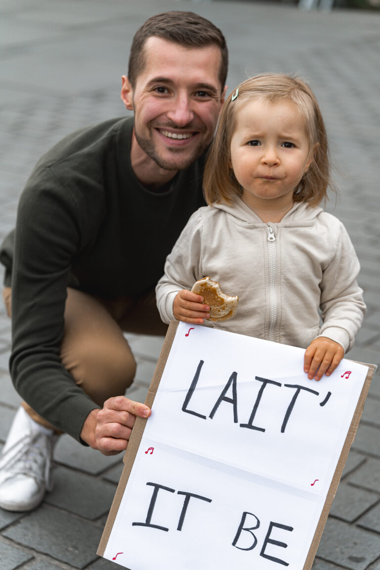 Papa et sa fille qui tiennent une pancarte devant la mairie lors de #jaifaimjemange 2025 à Bordeaux