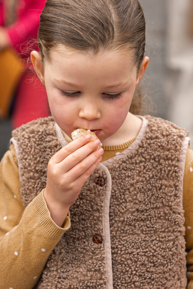 Petite fille qui mange un gâteau lors de #jaifaimjemange 2025 devant la mairie de Bordeaux