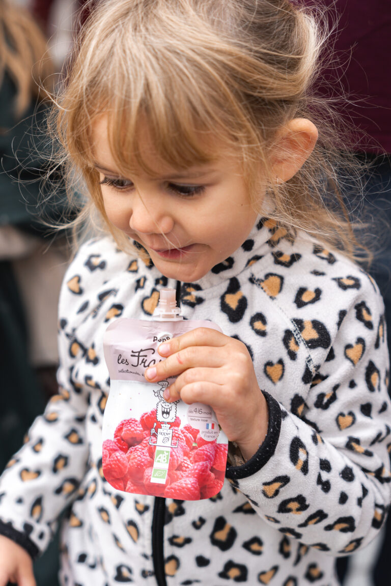 Petite fille qui mange la compote de notre partenaire popotte lors de #jaifaimjemange 2025 à Bordeaux