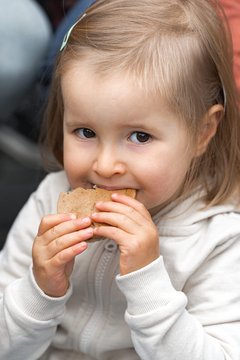 Petite fille qui mange un pancake en regardant l'objectif pendant #jaifaimjemange 2025 à Bordeaux