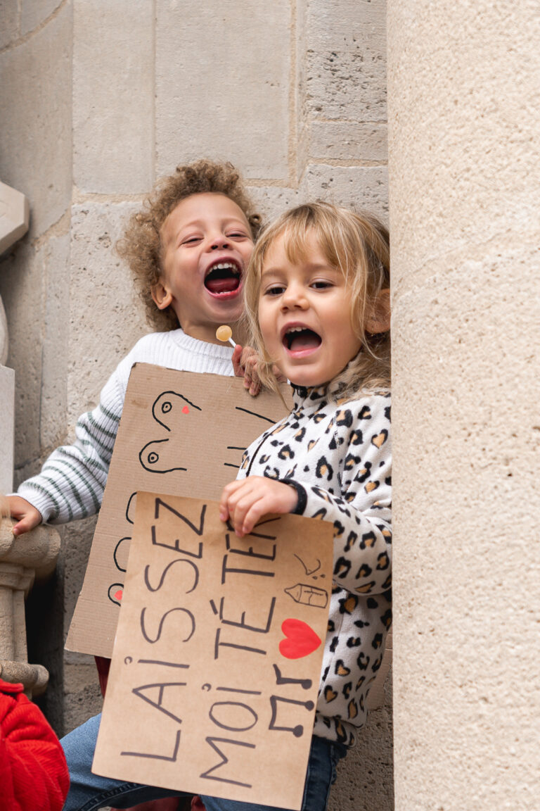 Deux enfants, un garçon et une fille qui tiennent des pancartes pour l'allaitement maternel lors de #jaifaimjemange 2025 à bordeaux, place Pey berland
