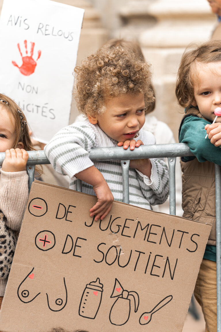 Petit garçon qui tient une pancarte par dessus une barrière en fronçant les sourcils lors de #jaifaimjemange 2025 à Bordeaux