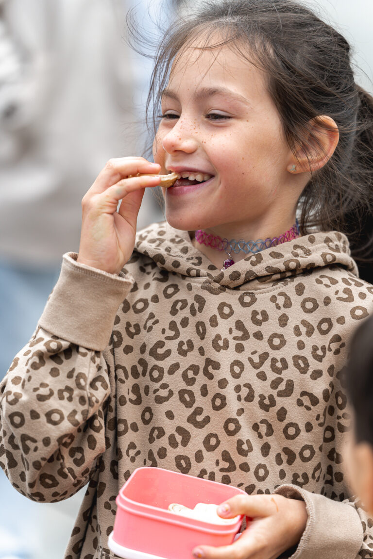 Jeune fille qui mange un cookie en riant lors de #jaifaimjemange 2025 à Bordeaux