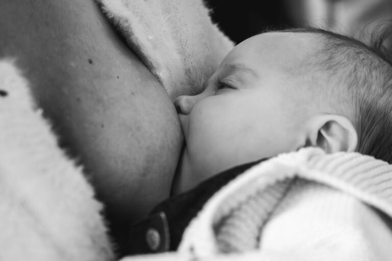 Photo en noir et blanc d'un bébé qui tète sa maman lors de #jaifaimjemange 2025 à Bordeaux