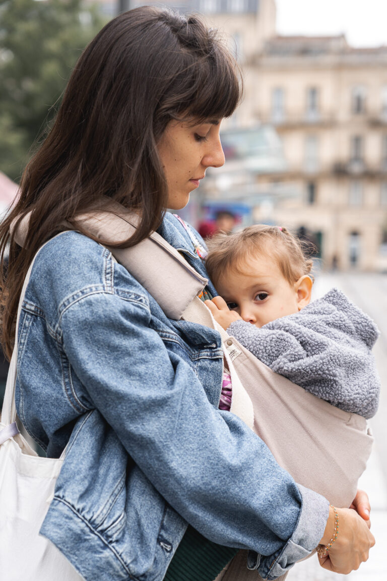 Maman qui regarde sa petite fille qu'elle allaite en portage lors de #jaifaimjemange 2025 à Bordeaux
