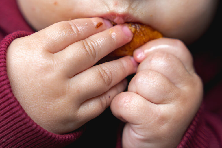 Gros plan sur la bouche et les mains d'un bébé qui mange du pain lors de #jaifaimjemange à bordeaux