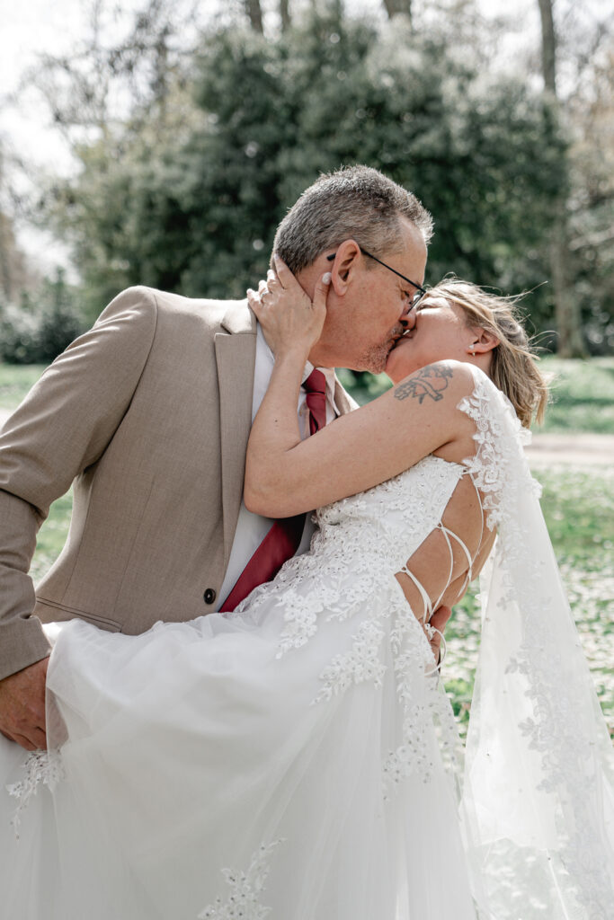 Jeunes mariés s'embrassant au Parc Majolan de Blanquefort lors de la séance couple de leur mariage