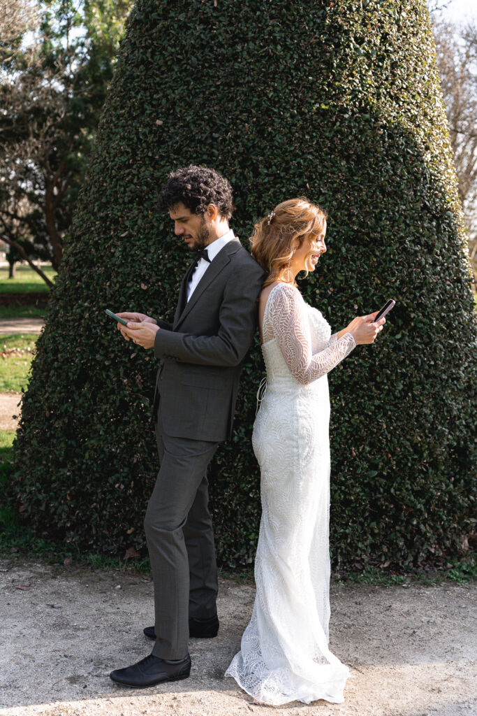 Jeunes mariés avec leur portable lors de la séance couple de leur mariage à Pessac pour rappeler leur début de relation