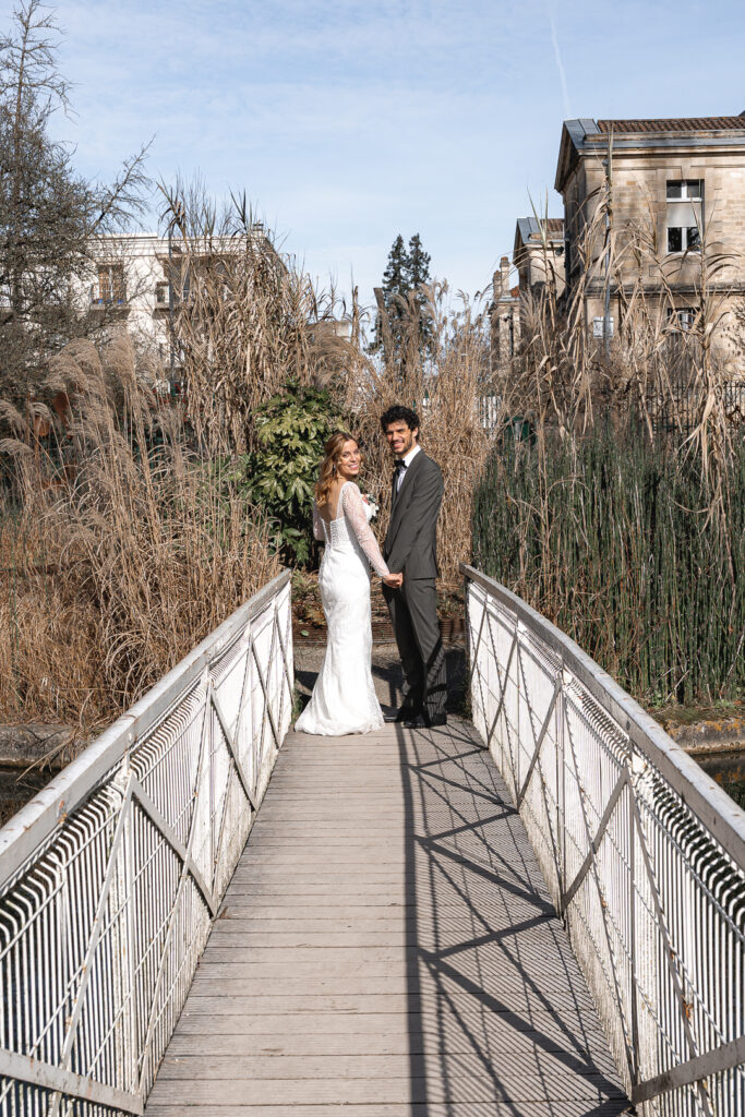 Jeunes mariés sur un pont lors de la séance couple de leur mariage à Pessac