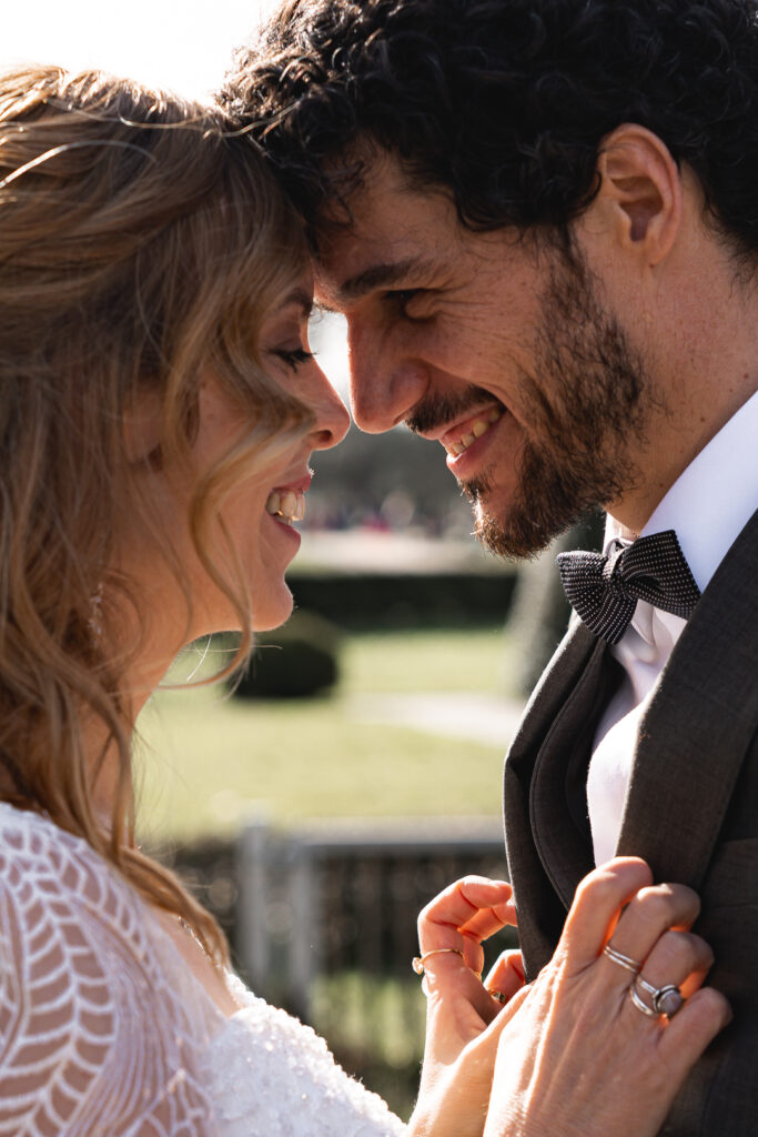 Jeunes mariés souriant front contre front lors de la séance couple de leur mariage à Pessac