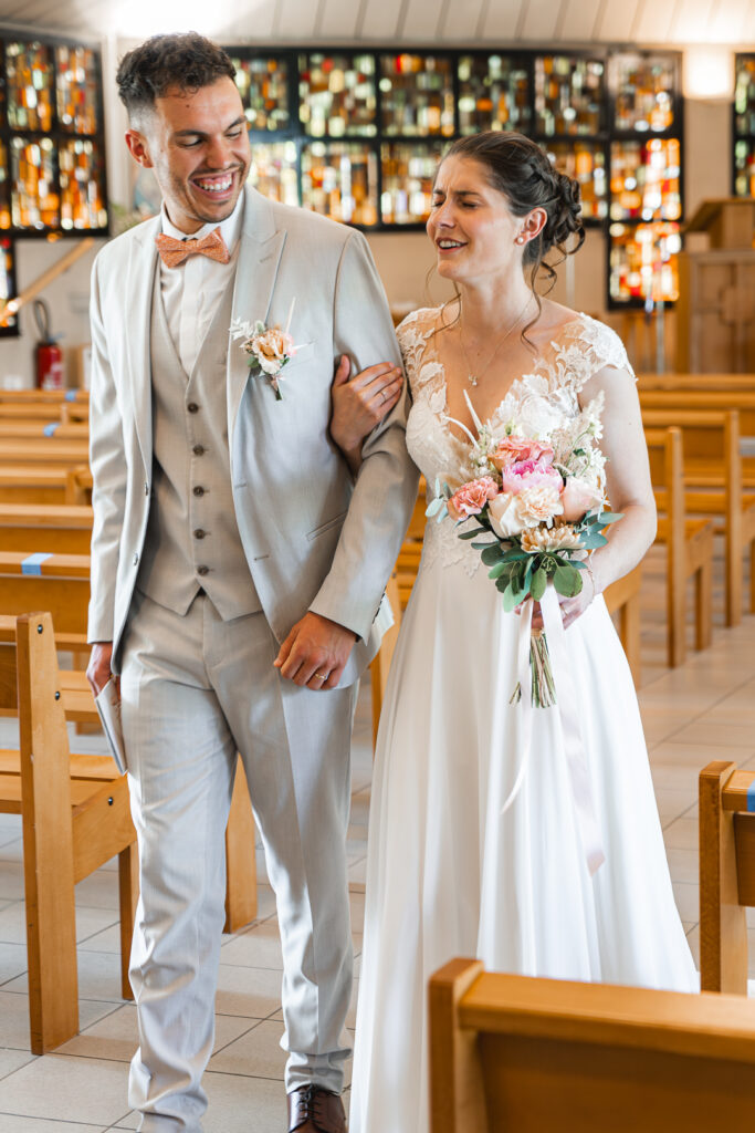 Couple chantant sur la musique de sortie de l'église lors de leur reportage mariage