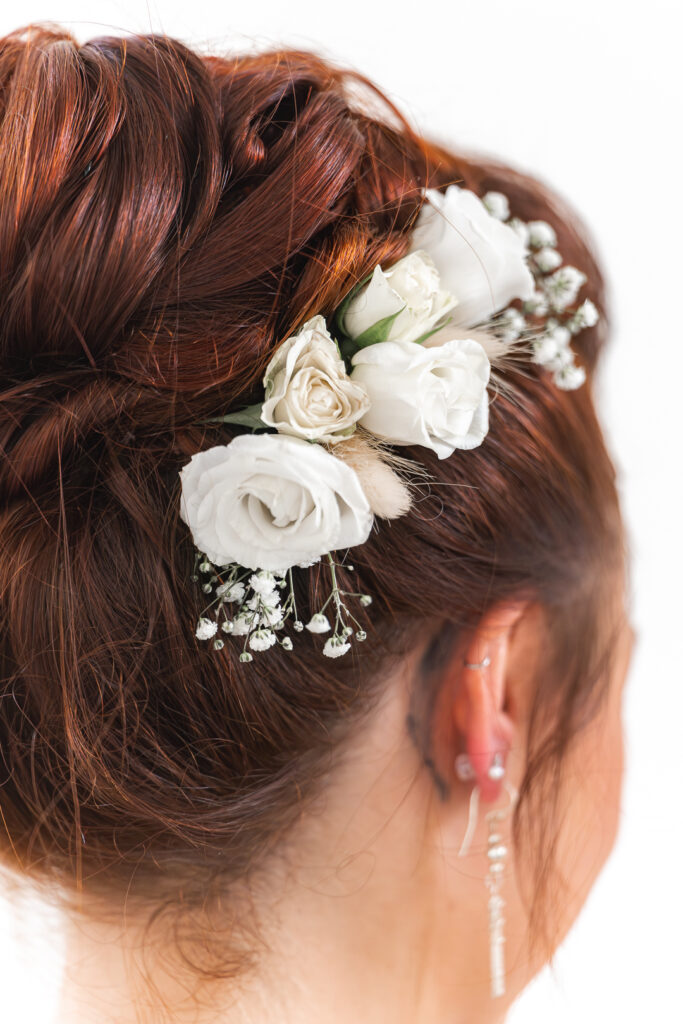 Détails de la broche de fleurs dans la coiffure de la mariée lors de son mariage