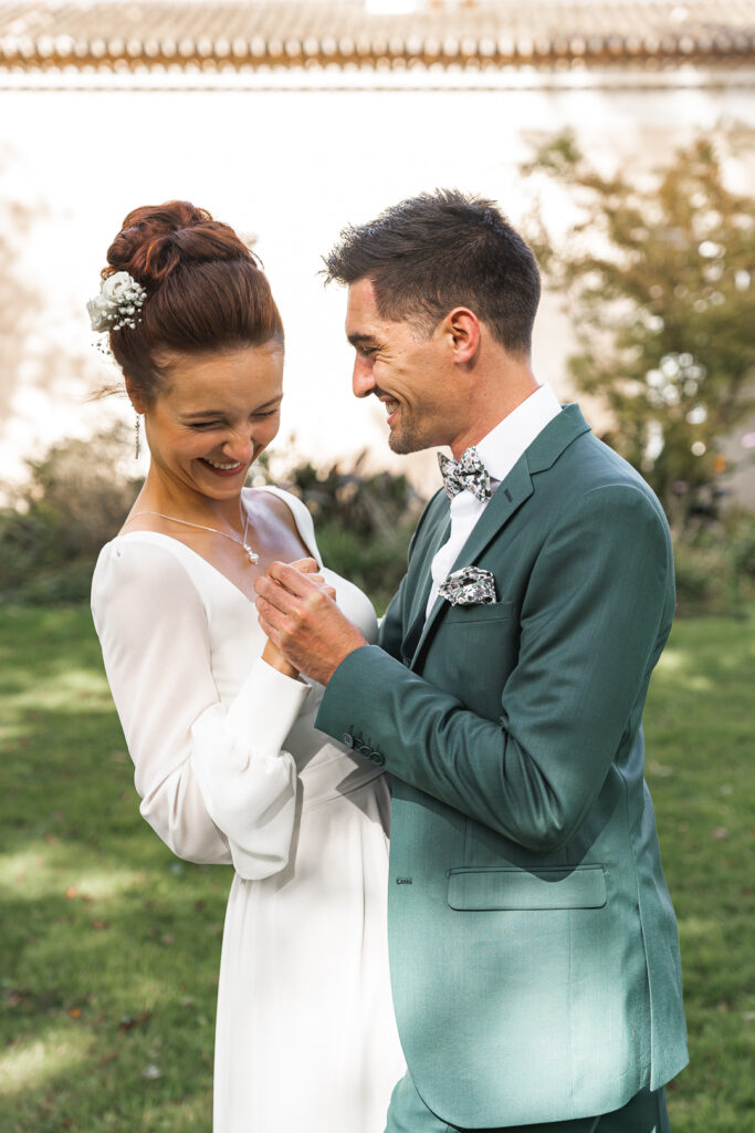 Jeunes mariés riant lors d'un jeu de la séance couple de leur mariage