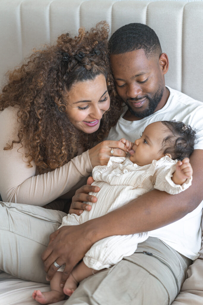 Bébé dans les bras de ses parents lors d'une séance naissance lifestyle à domicile à Pessac