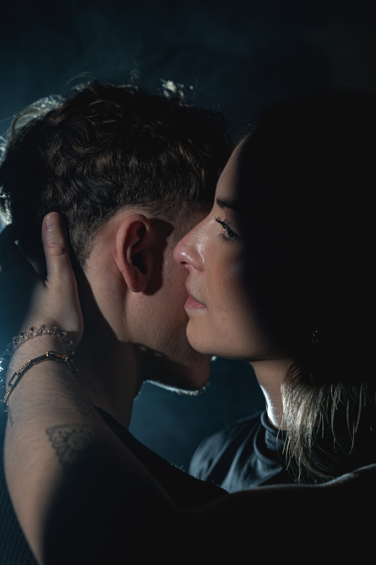 Jeune femme qui murmure à l'oreille de son copain lors d'une séance photo couple à mon home studio sur Bordeaux