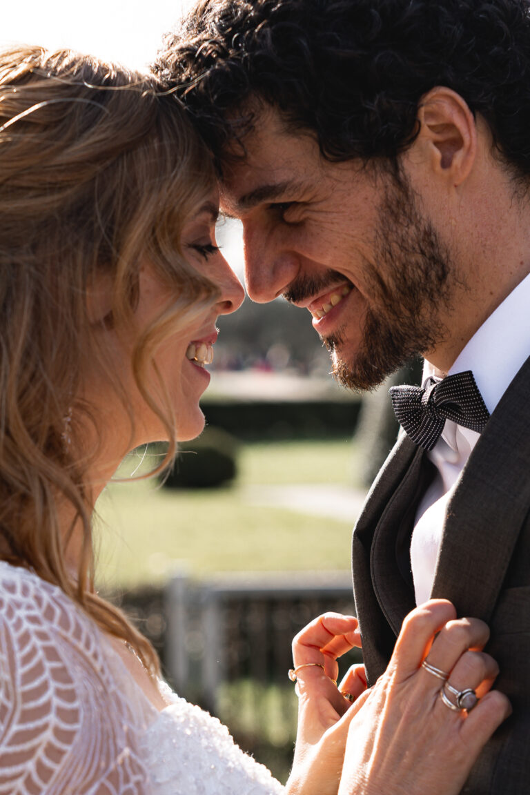 Mariés front contre front qui sourient lors de la séance photo de couple de leur mariage civile à Pessac