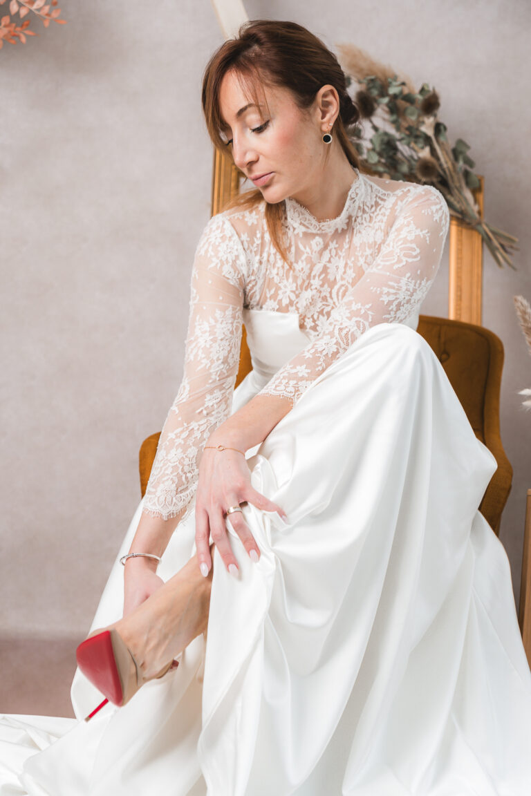 Portrait de la mariée qui met ses chaussures pendant les préparatifs de son mariage à Bordeaux