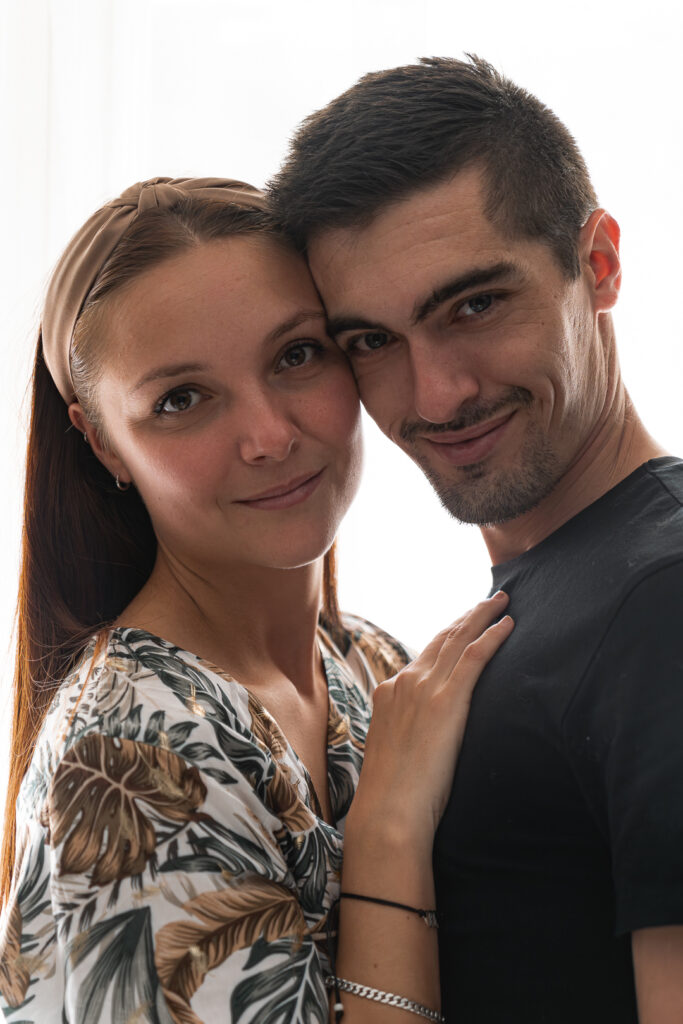 Couple joue contre joue avec petit sourire au coin lors d'une séance couple au Home studio