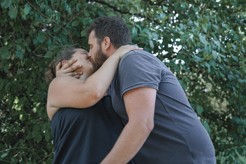 Homme qui embrasse fougueusement sa femme en la renversant durant une séance couple