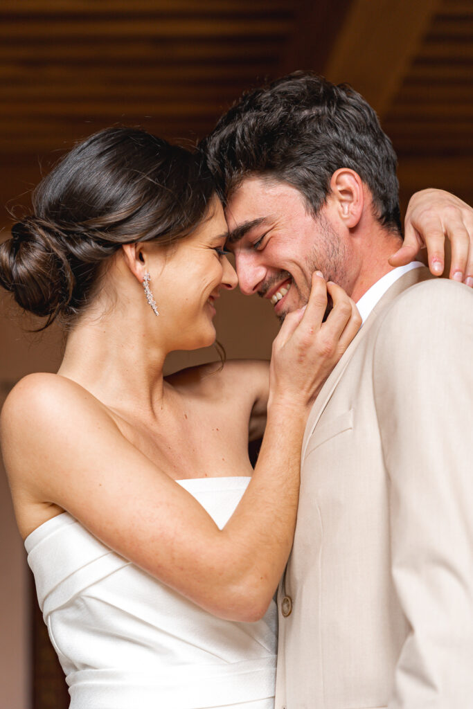 Futurs mariés front contre front qui rient en se regardant dans les yeux lors de la séance couple de leur mariage