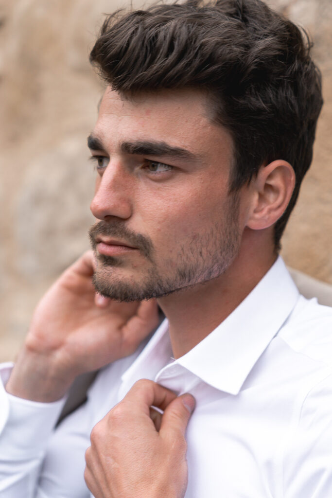 Portrait du marié adossé à un mur lors de son mariage