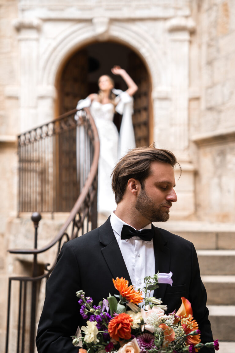 Marié qui attend sa femme pour le premier regard sur la robe de mariée de leur mariage au château de Dio