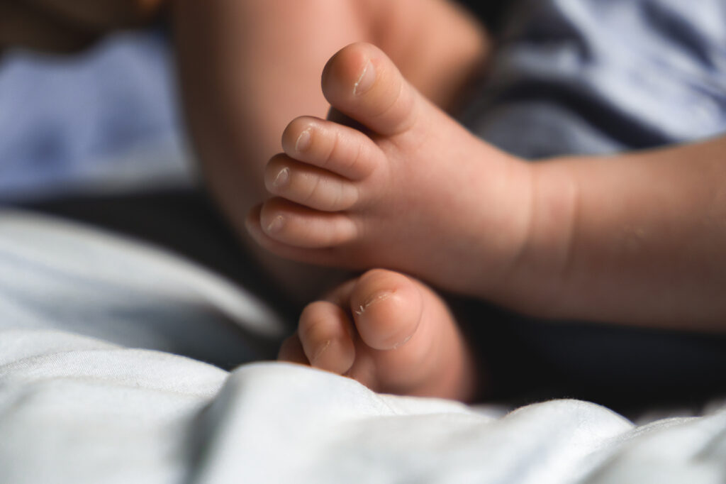 Détails des pieds d'un bébé nouveau-né lors d'une séance naissance lifestyle à domicile à Blanquefort