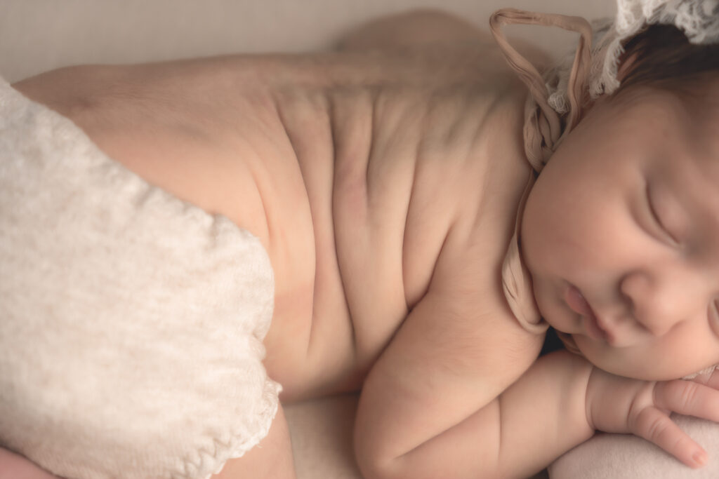 Gros plan sur les détails des bourrelets d'un bébé nouveau-né lors d'une séance naissance en baby-posing à mon home studio à Bordeaux