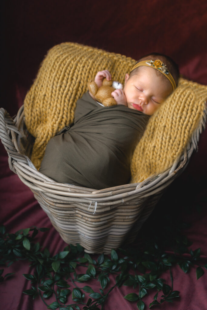 Bébé nouveau-né emmailloté en baby posing dans un panier haut lors d'une séance naissance en home studio à Bordeaux