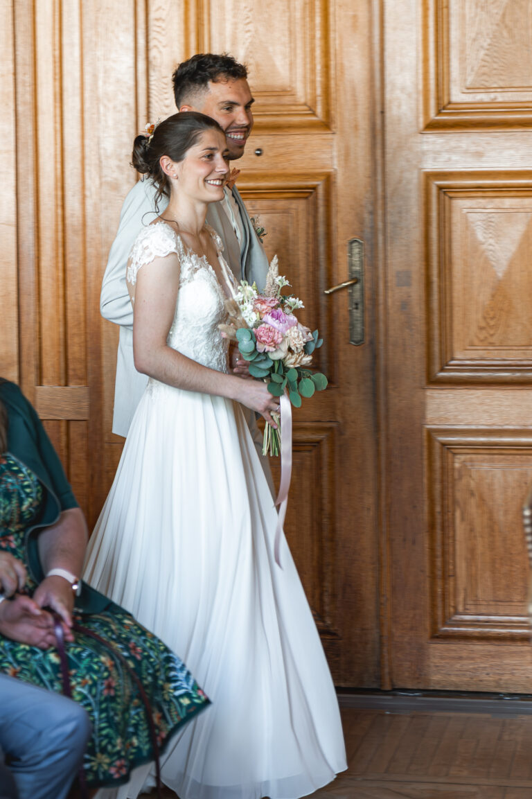Mariés qui entrent dans la mairie en souriant lors de leur mariage civil à Nantes
