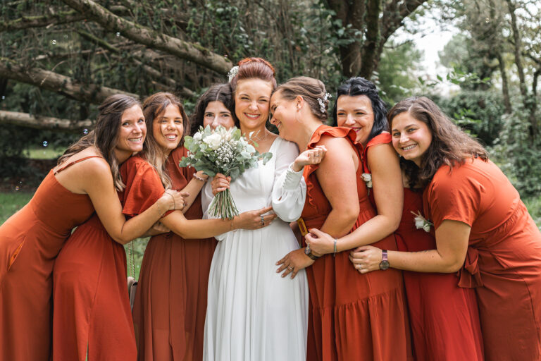 Photo de groupe de la mariée entourée de ses demoiselles d'honneur dans un calin lors de son mariage à Eysines