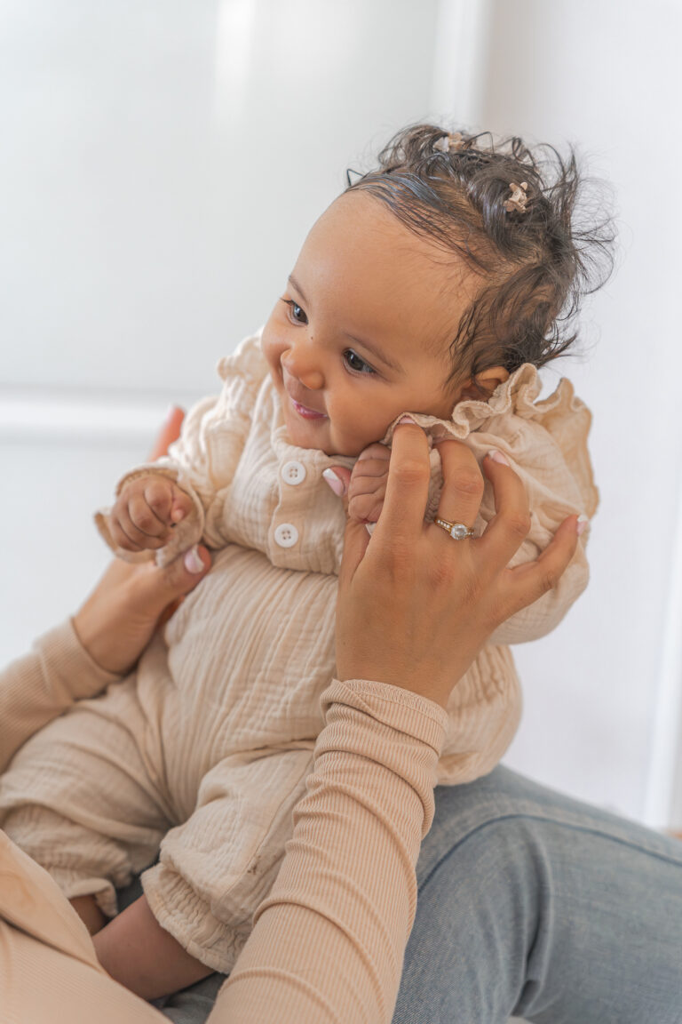 Bébé entre les mains de sa maman lors d'un shooting bébé à domicile à Pessac