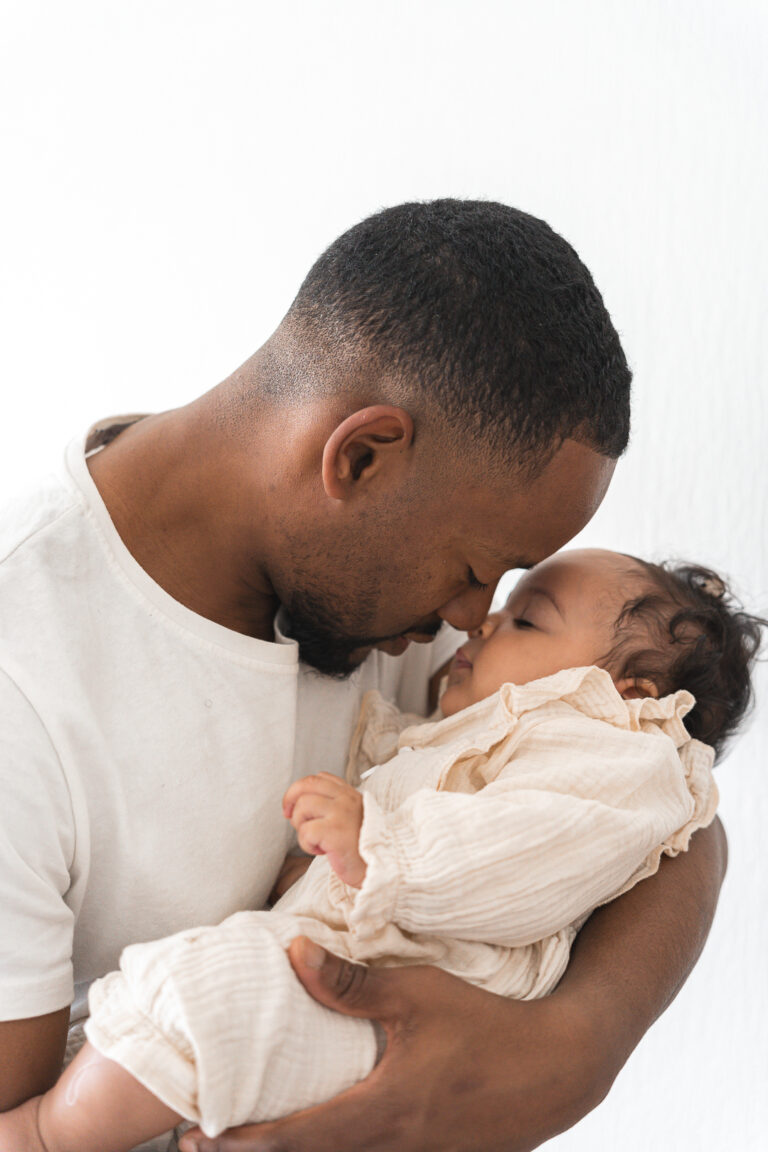 Bébé nez contre nez avec son papa lors d'un shooting bébé à domicile à Pessac