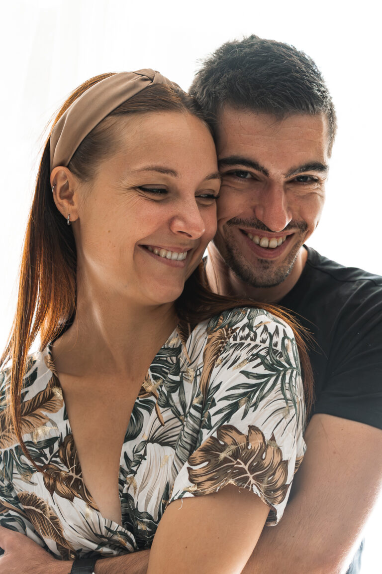 Couple qui s'enlace en riant lors d'une seance photo couple à mon home studio sur bordeaux