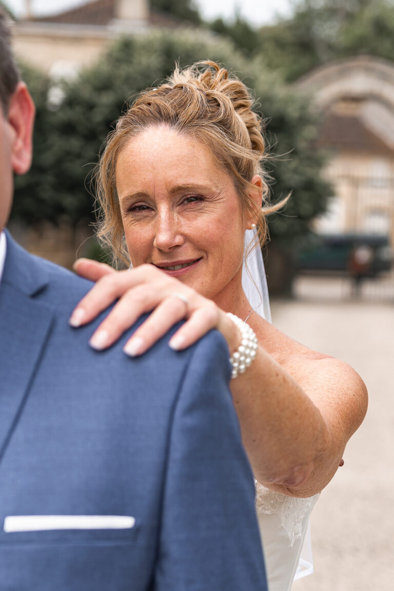 Mariée sur le point de dévoiler sa robe de mariée à son époux lors de la séance photo couple de leur mariage civile à Plassac