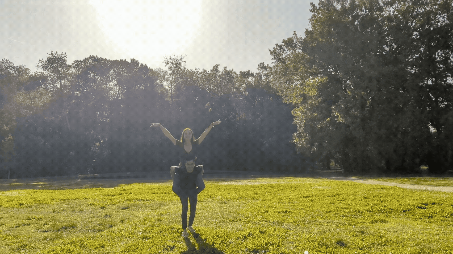 Jeune homme qui court avec sa fiancée sur le dos lors d'une séance couple au Parc de Majolan à Blanquefort