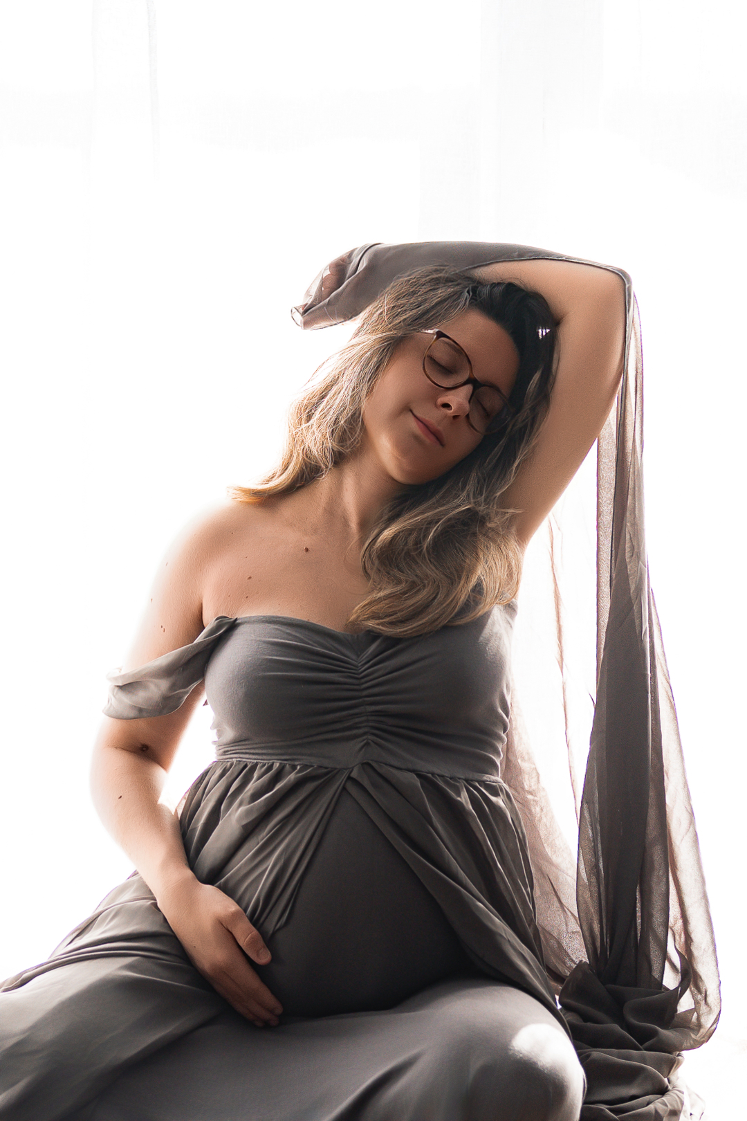 photographe de maternité enceinte dans une robe style grec lors de sa séance photo grossesse à son home studio à Bordeaux