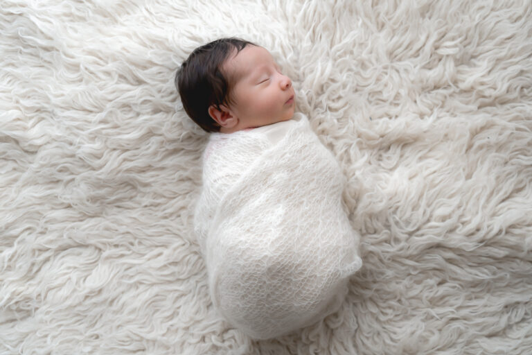 Bébé emmailloté sur un plaid lors d'un shooting photo bébé à mon home studio sur bordeaux