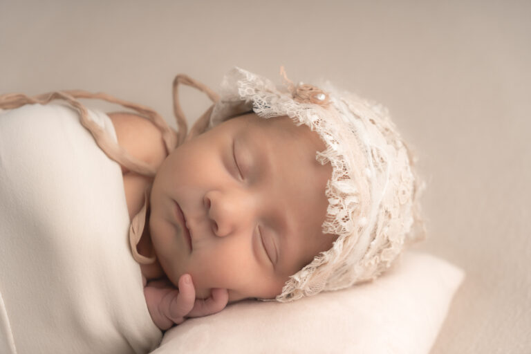 Nouveau-né qui dort emmailloté avec un béret lors d'un shooting nouveau-né à mon home studio sur bordeaux